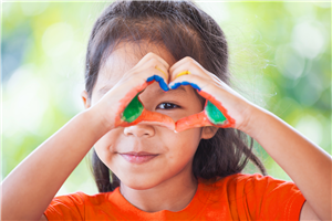 Girl making heart shape with hands